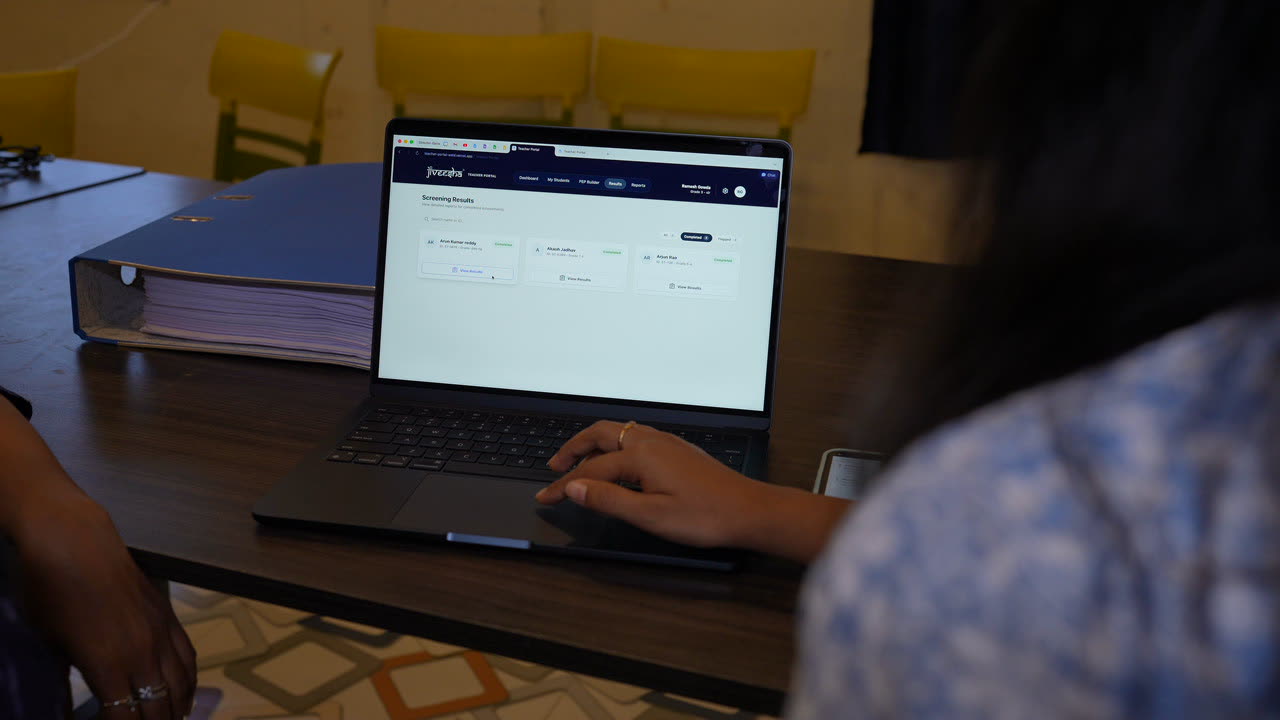 Hands typing on a laptop running the Jiveesha platform