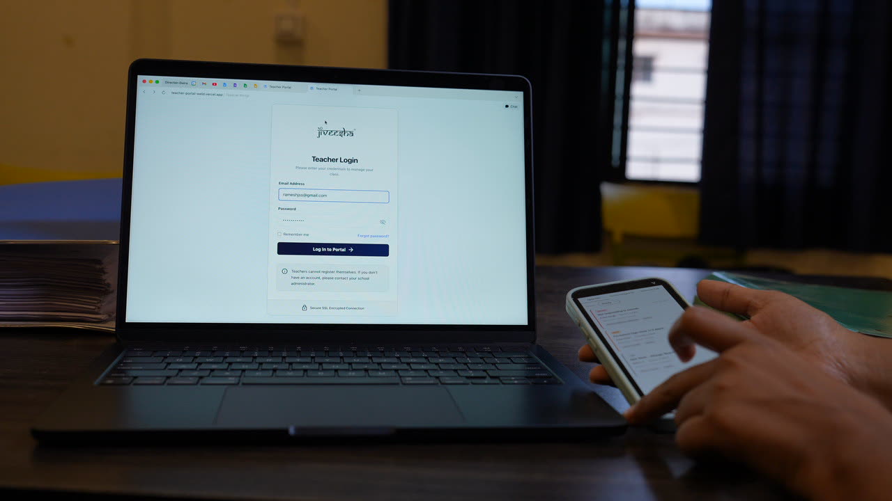 A laptop showing the Jiveesha teacher login screen beside a phone