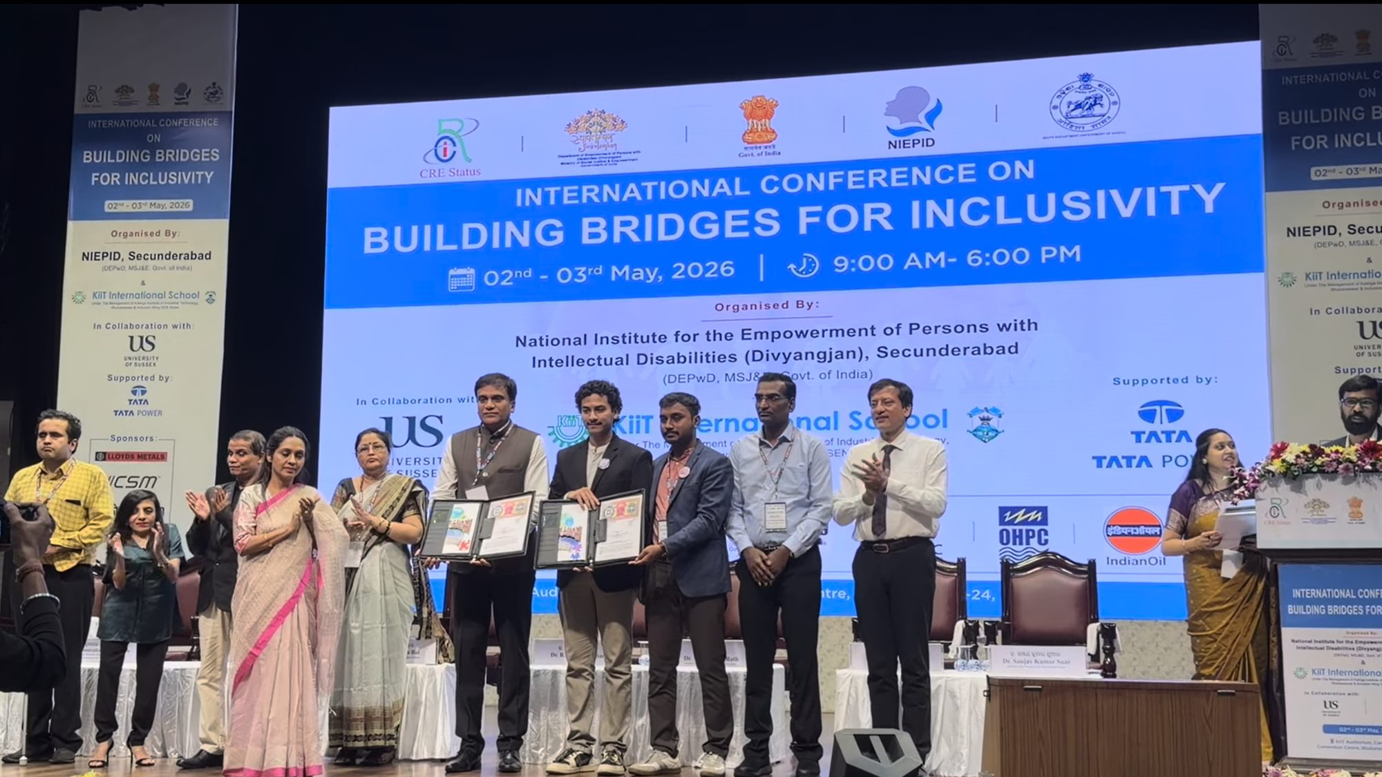 The Daira and NIEPID teams on stage holding the signed MoU folders at the International Conference on Building Bridges for Inclusivity