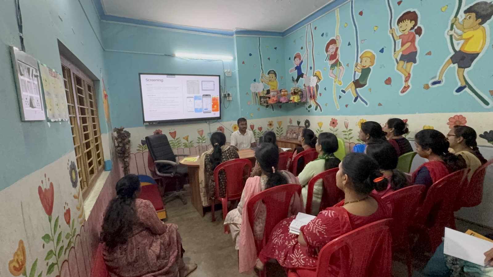 Audience of teachers watching a training presentation on screen