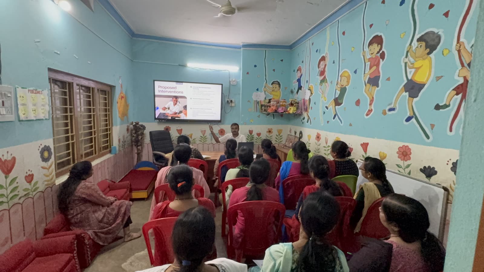 Teachers at a training session watching a Jiveesha presentation on screen